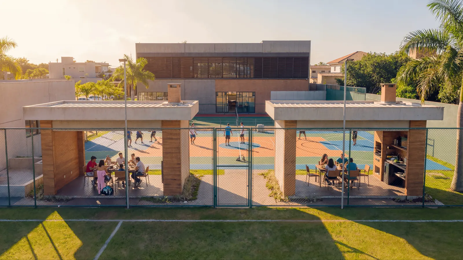 Render das quadras em uso no fim de tarde, com churrasco nos quiosques
